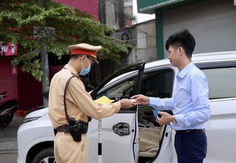 Cảnh sát giao thông kiểm tra giấy tờ của người đi đường chủ xe ô tô